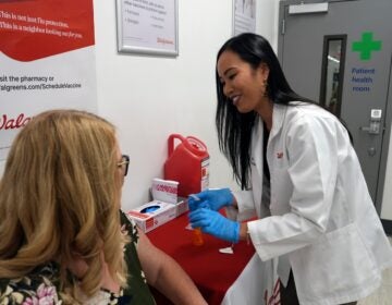 Anh Nguyen prepares to administer a COVID-19 vaccine