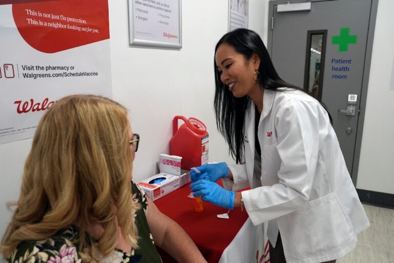 Anh Nguyen prepares to administer a COVID-19 vaccine