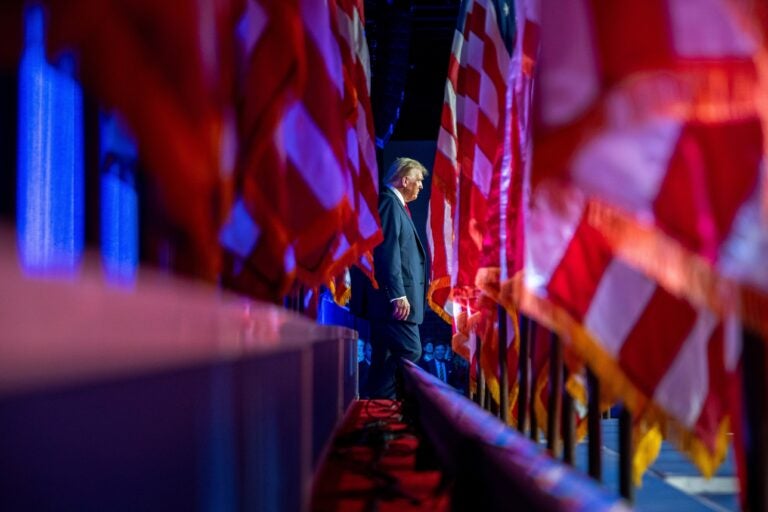 Donald Trump standing in sight of multiple U.S. flags