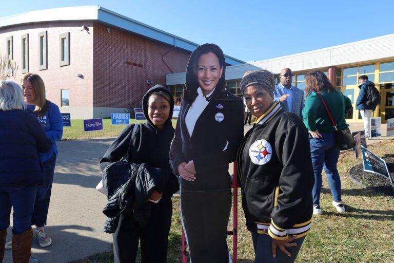 Adrena Loren and Zaiyae Carter pose with a Harris cutout in front of Scranton High School on Election Day