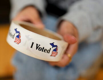 A poll worker holds a roll of 