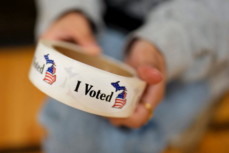 A poll worker holds a roll of 