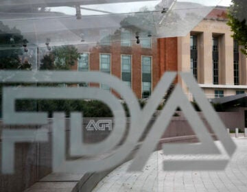 A U.S. Food and Drug Administration building is seen behind FDA logos at a bus stop on the agency's campus in Silver Spring, Md., in 2018. Cucumbers shipped to the U.S. and Canada, and organic eggs sold in 25 Costco stores in five southern U.S. states, were recalled this week for potential salmonella contamination. (Jacquelyn Martin/AP)