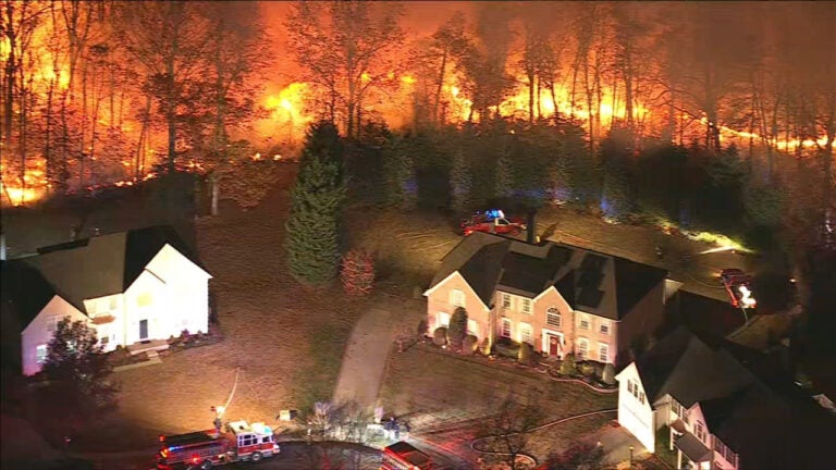 A wildfire burning near homes