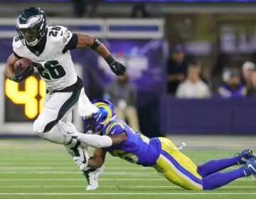 agles running back Saquon Barkley, left, runs against Los Angeles Rams safety Kamren Kinchens during the first half of an NFL football game in Inglewood, Calif., Sunday, Nov. 24, 2024.