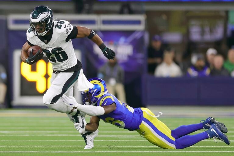 agles running back Saquon Barkley, left, runs against Los Angeles Rams safety Kamren Kinchens during the first half of an NFL football game in Inglewood, Calif., Sunday, Nov. 24, 2024.