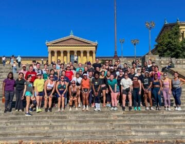 Philly Slow Girl Run Club posing for a photo on the steps of the art museum.