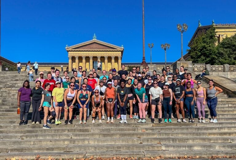 Philly Slow Girl Run Club posing for a photo on the steps of the art museum.