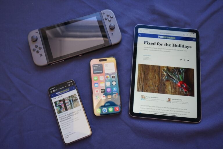 two phones, a tablet and a gaming device on a table