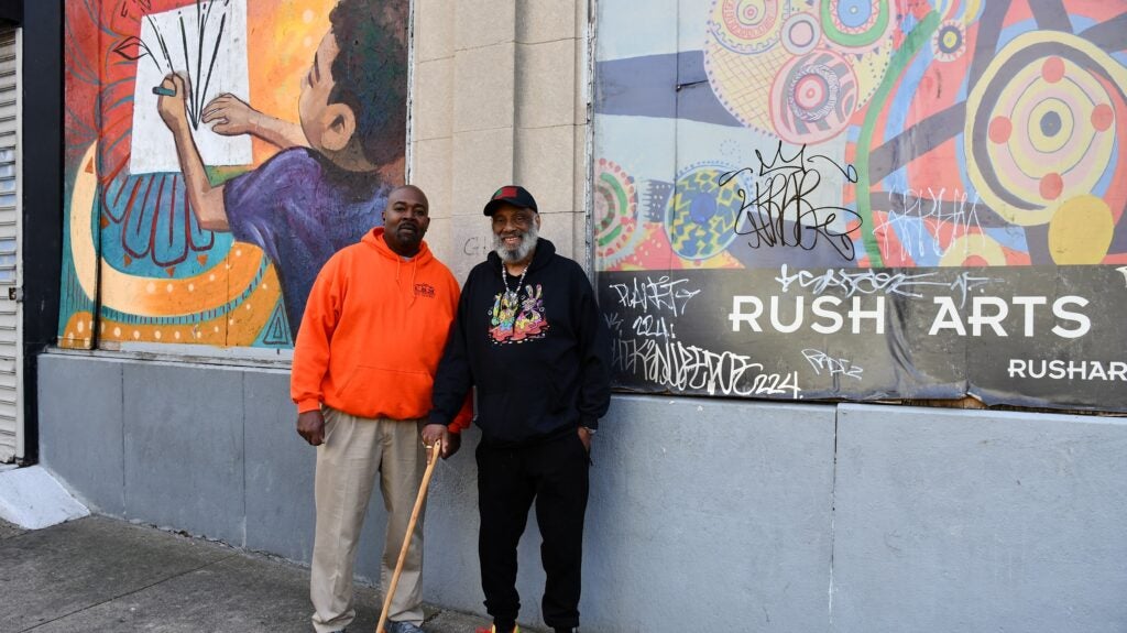 Marc McKee and Danny Simmons stand and smile outside