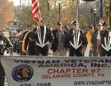 Veterans hold a banner reading VIETNAM VETERANS AMERICA INC. CHAPTER 67 DELAWARE COUNTY, PA