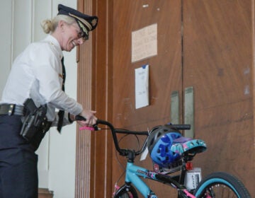 Jennifer Griffin smiles and holds a bike