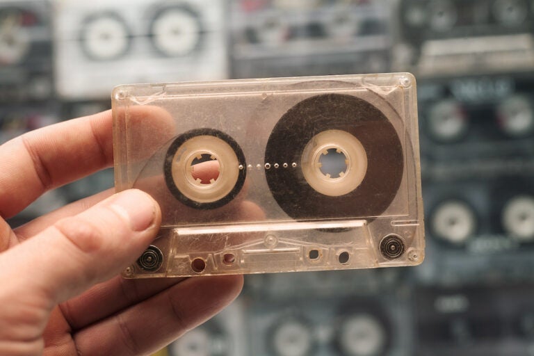 A person holds one old cassette tape out of many. (Bigstock/Tik.Tak)