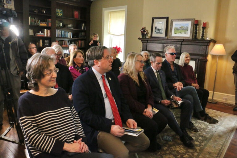 a crowd sitting in chairs in the home