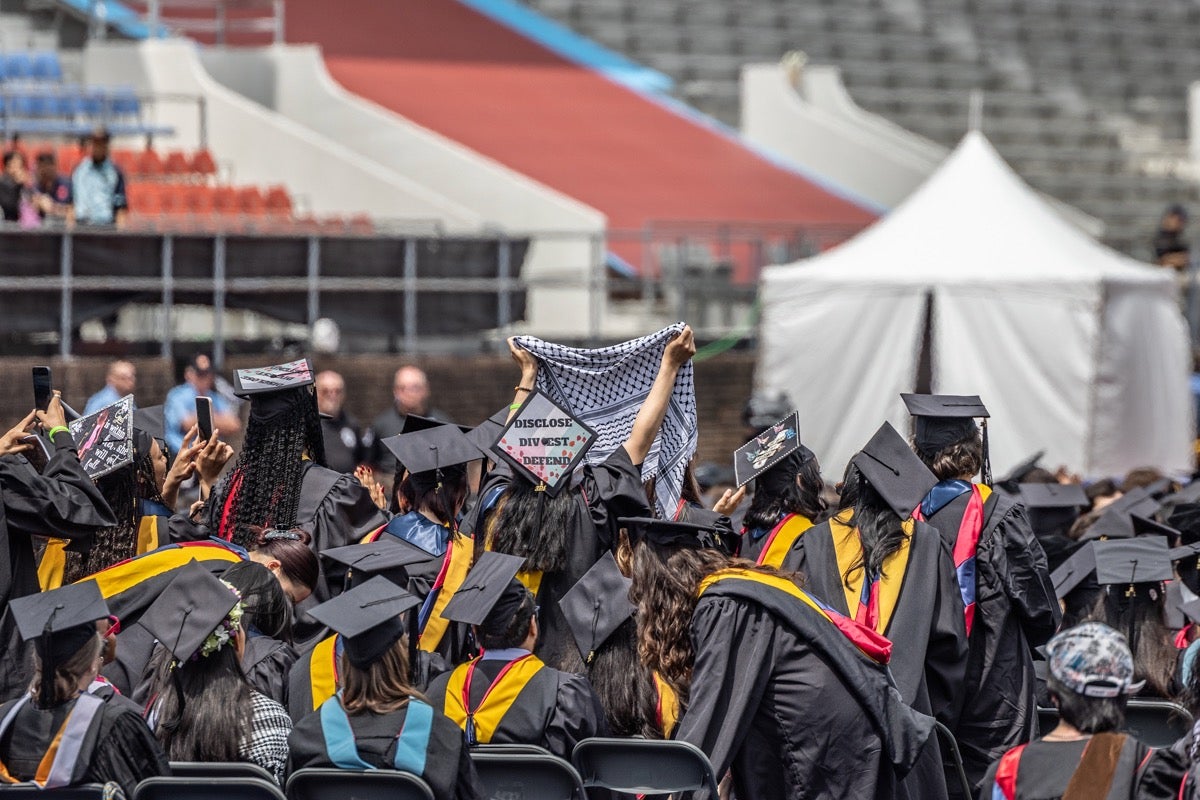 Students wave keffiyeh at an University of Pennsylvania encampment