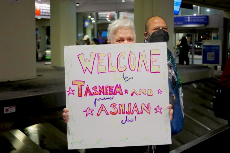 People holding up signs in the airport