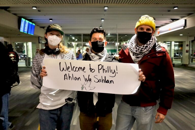 People holding up signs in the airport