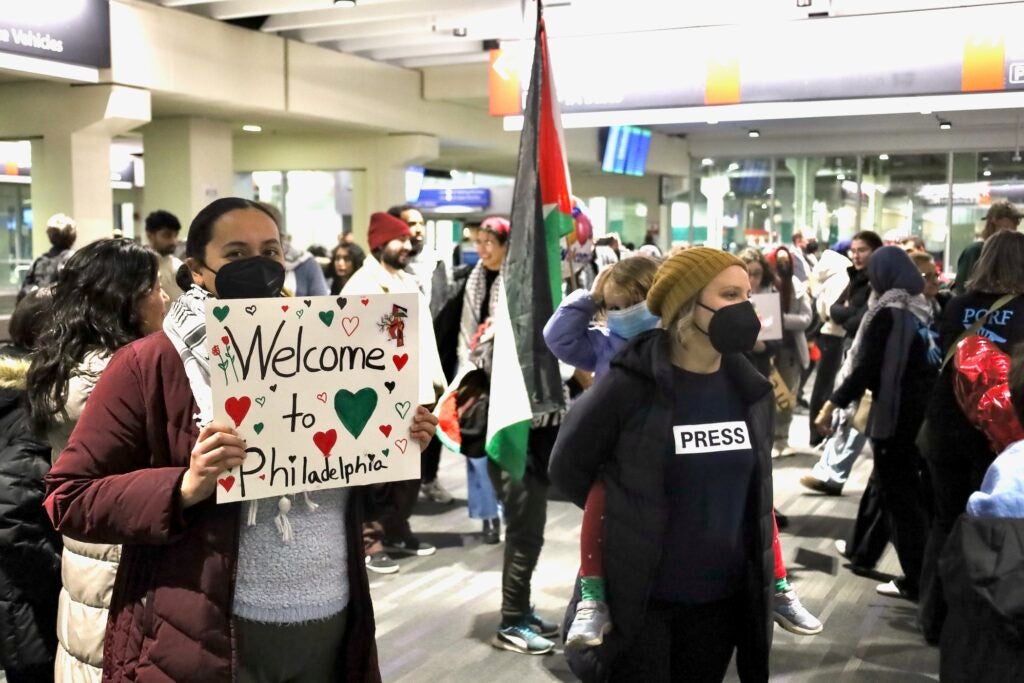 People holding up signs in the airport