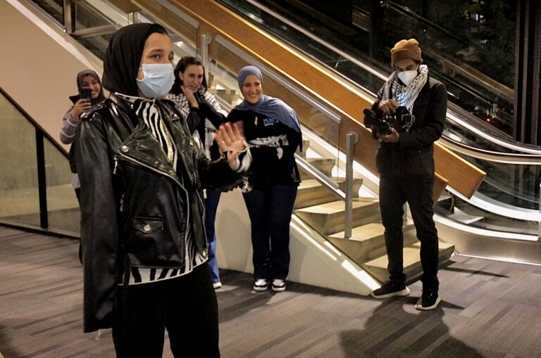 Tasneem Abbas waving to people after arriving at the airport