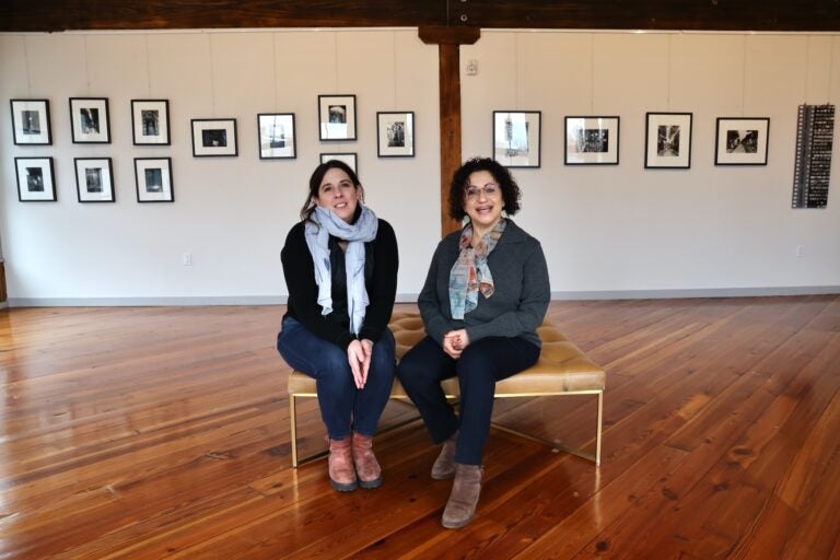 Al-Bustan's Executive Director Lisa Volta (left) invited founder Hazami Sayed (right) to be the first artist to exhibit in the organization's new space in Kensington. Sayed's exhibition of photographs and clay works is titled ''Imprints of Time and Place.'' (Emma Lee/WHYY)