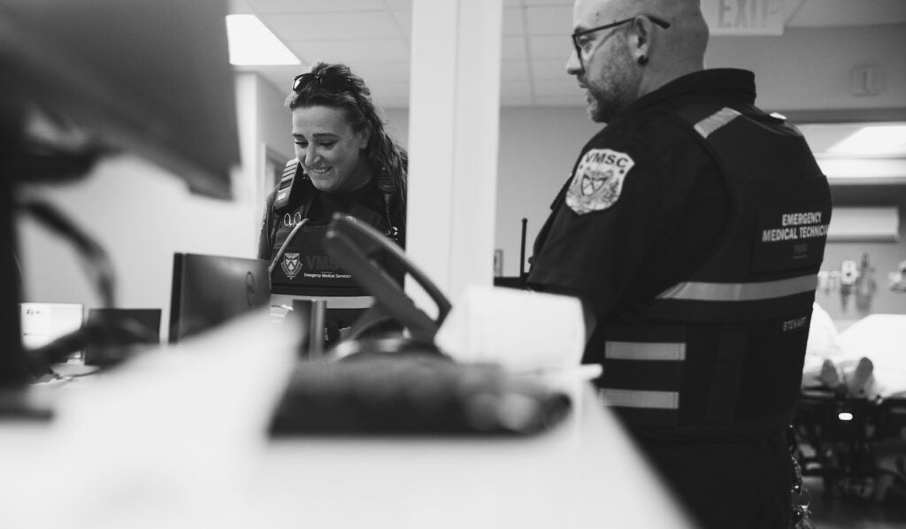 Two people working at a desk in a black and white photo