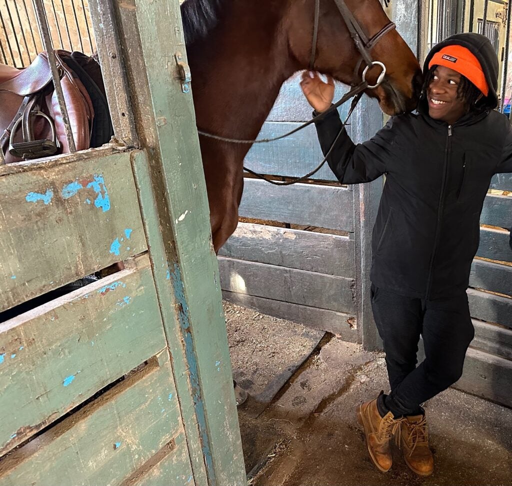 Marc-Anthony Harley smiles with a horse