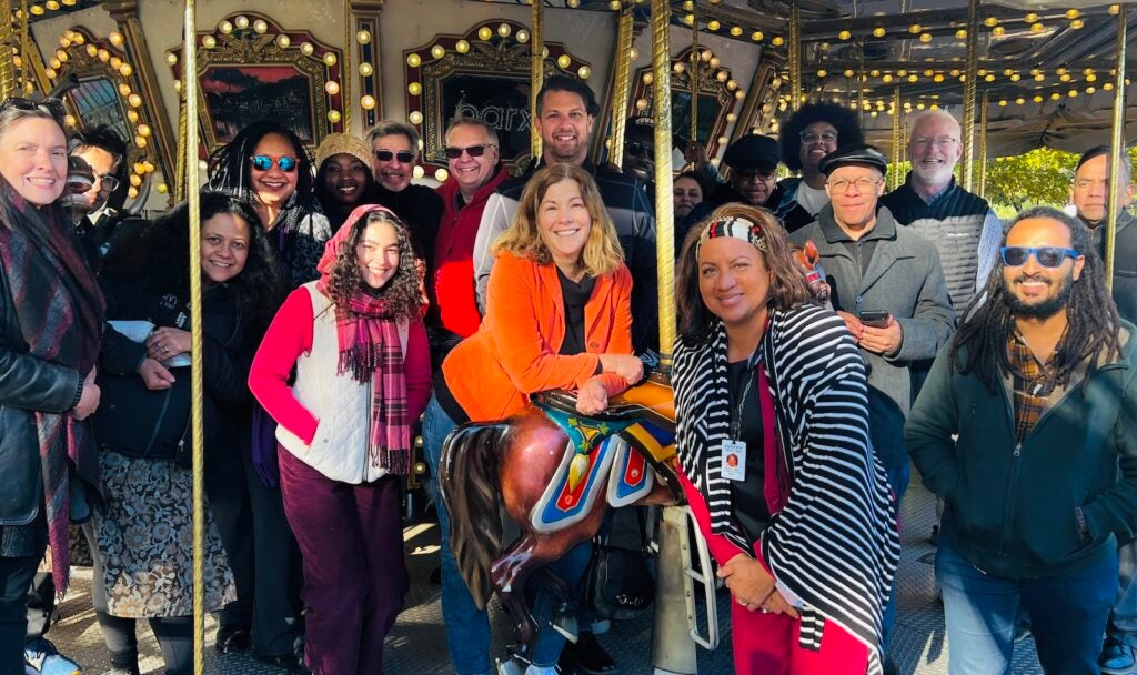 WHYY News staff participate in a team building exercise including the merry-go-round and mini-golf at Franklin Square Park.