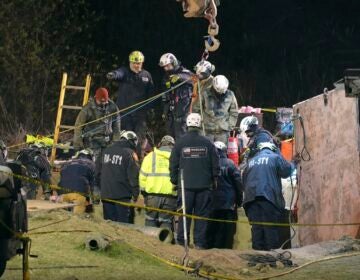 Rescue workers search in sinkhole