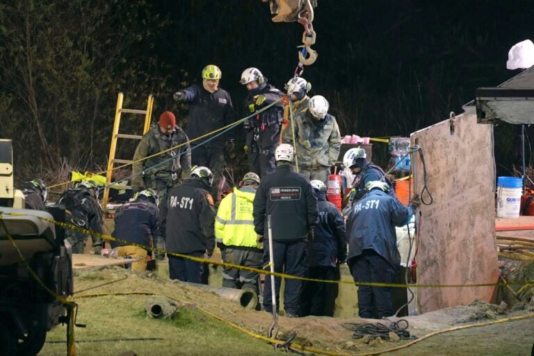 Rescue workers search in sinkhole