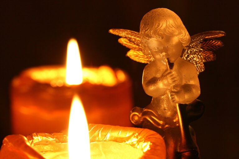 transparent decoration angel making music upon Advent wreath