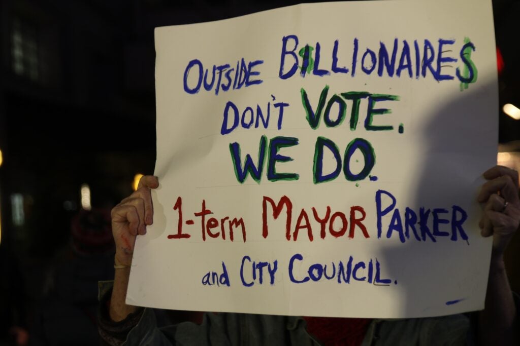 A sign being held up by a protester says 'Outside billionaires don'g vote. we do"