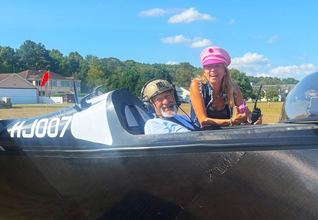 John Chirtea sits in the cockpit while his daughter Heather stands next to their flying car