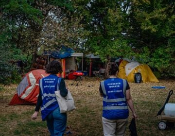 Outreach workers walking into a homeless encampment