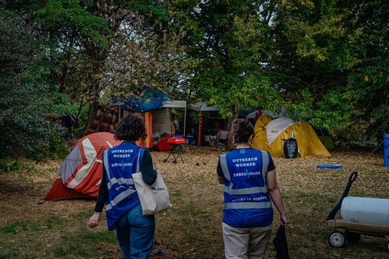 Outreach workers walking into a homeless encampment