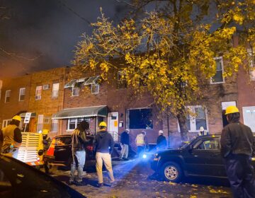 Crews stand at the scene of a gas explosion at a South Philly home