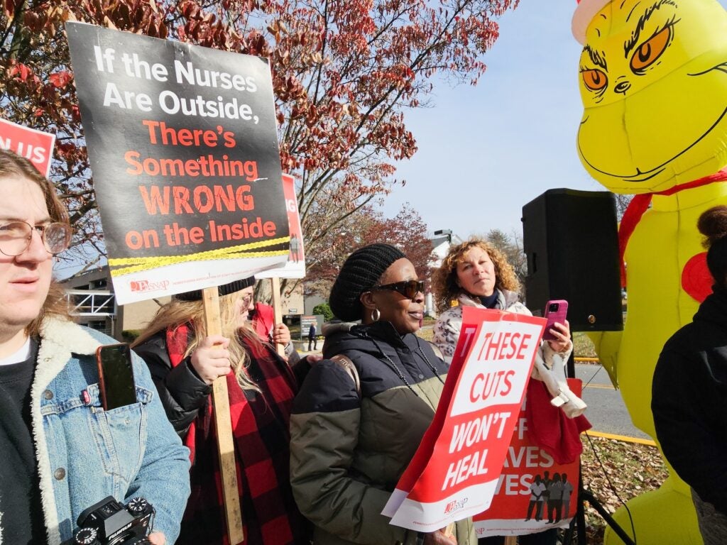 people marching on a picket line holding up signs