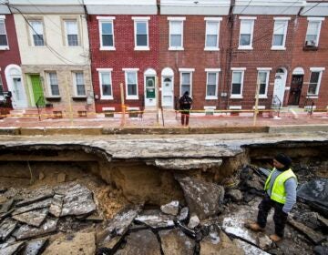 Workers inspect a sinkhole in Philadelphia