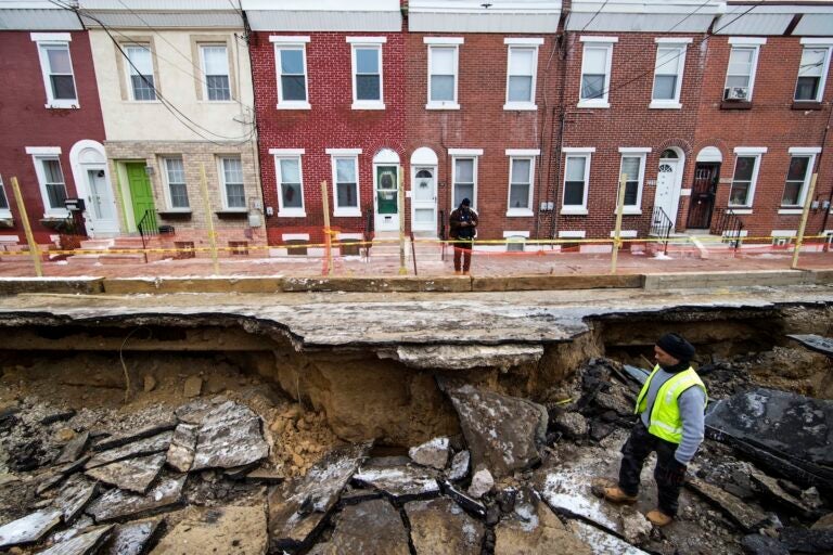 Workers inspect a sinkhole in Philadelphia