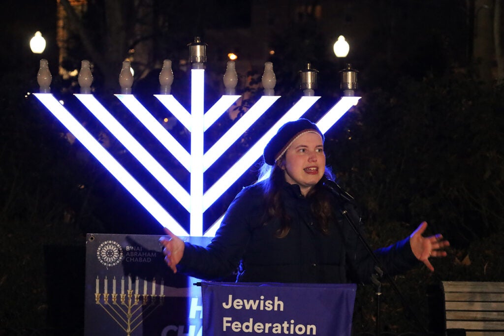 A woman rabbi speaks in front of a menorah in Philadelphia