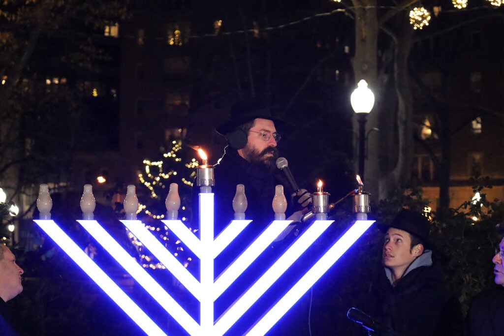 A male rabbi lights a menorah in Philadelphia