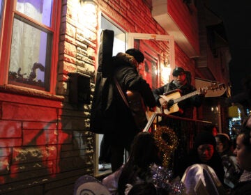 A procession gathers outside of a home