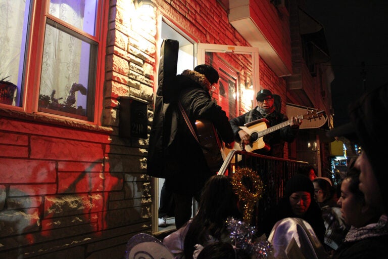 A procession gathers outside of a home