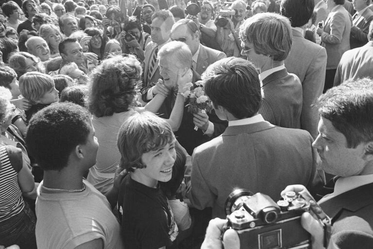 A Secret Service Agent helps U.S. President Jimmy Carter pull away from an unidentified woman who kissed him while he visited a family in suburban Lansdowne, Pennsylvania, Thursday, Oct. 2, 1980. Carter was spending part of Thursday in the Philadelphia campaigning for a second term.