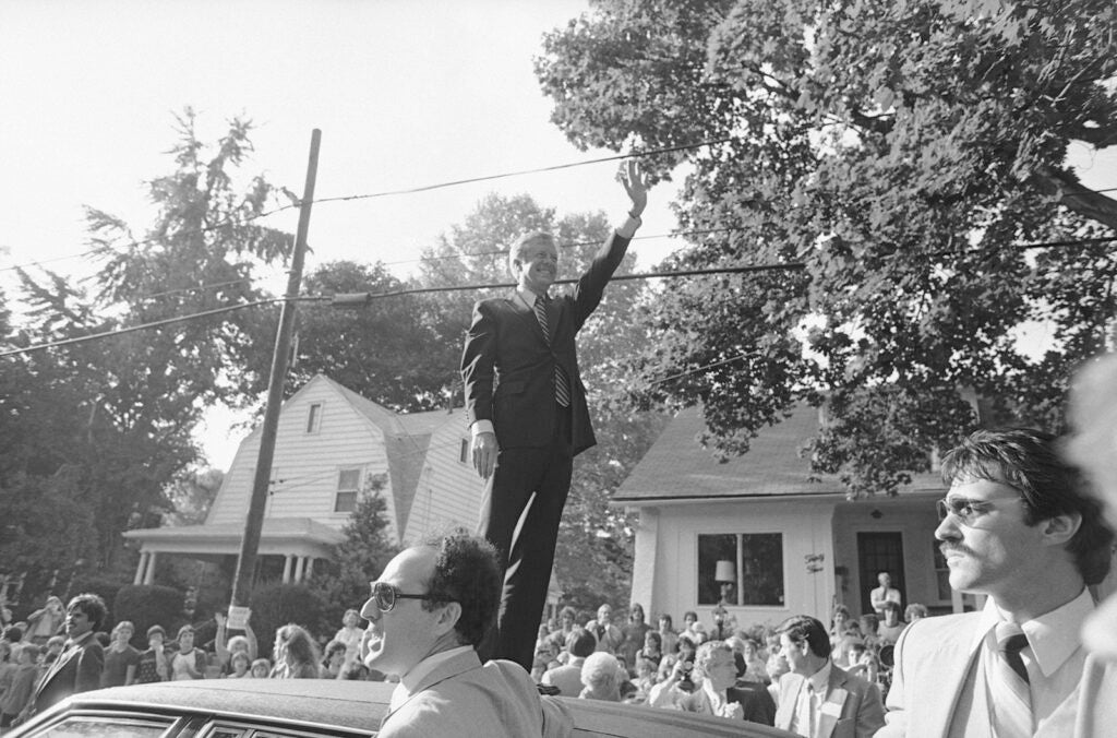 U.S. President Jimmy Carter stands on top of the presidential limousine and waves good by to the crowd that gathered during his visit to suburban Lansdowne, Pennsylvania, Thursday, Oct. 3, 1980. Carter spent the afternoon campaigning in the Philadelphia area.