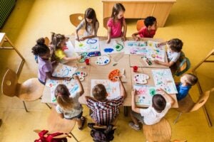 High angle view of large group of elementary students having an art class in the classroom.
