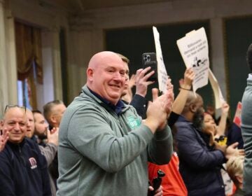 Supporters standing and clapping in the audience