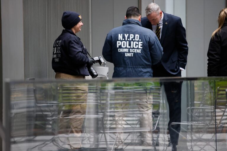 Members of the New York police crime scene unit investigate the scene outside the Hilton Hotel