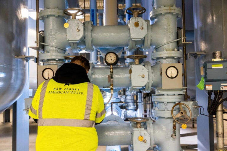 A worker is seen next to a water filtration system