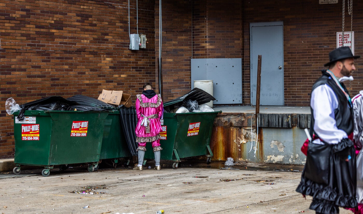 Mummer urinates on a dumpster