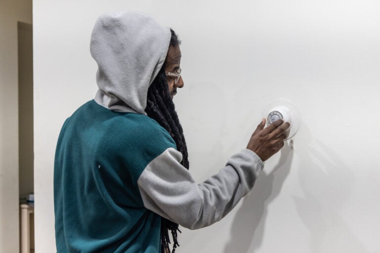 Naim Scott adjusting the apartment's thermostat